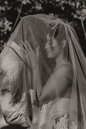 Close-up black and white portraits of a bride wearing a delicate lace veil in an artistic composition.