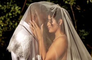 Romantic outdoor bridal portraits with sunlit veil creating ethereal lighting effects.