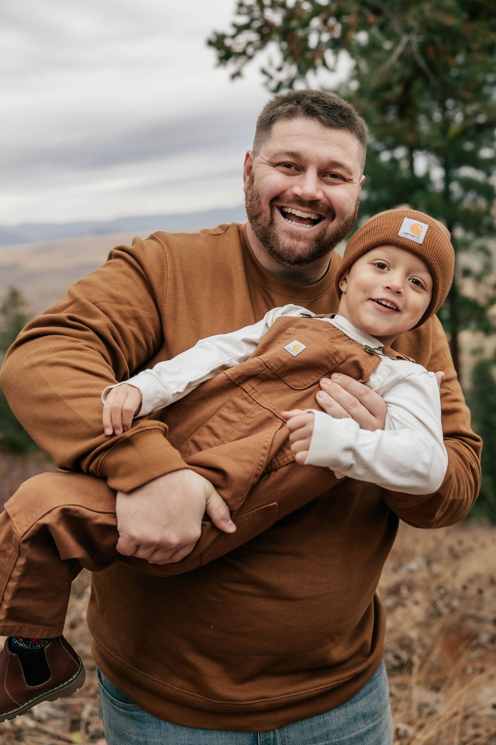 Playful sequence of a parent and child in brown jackets sharing laughs and hugs outdoors.