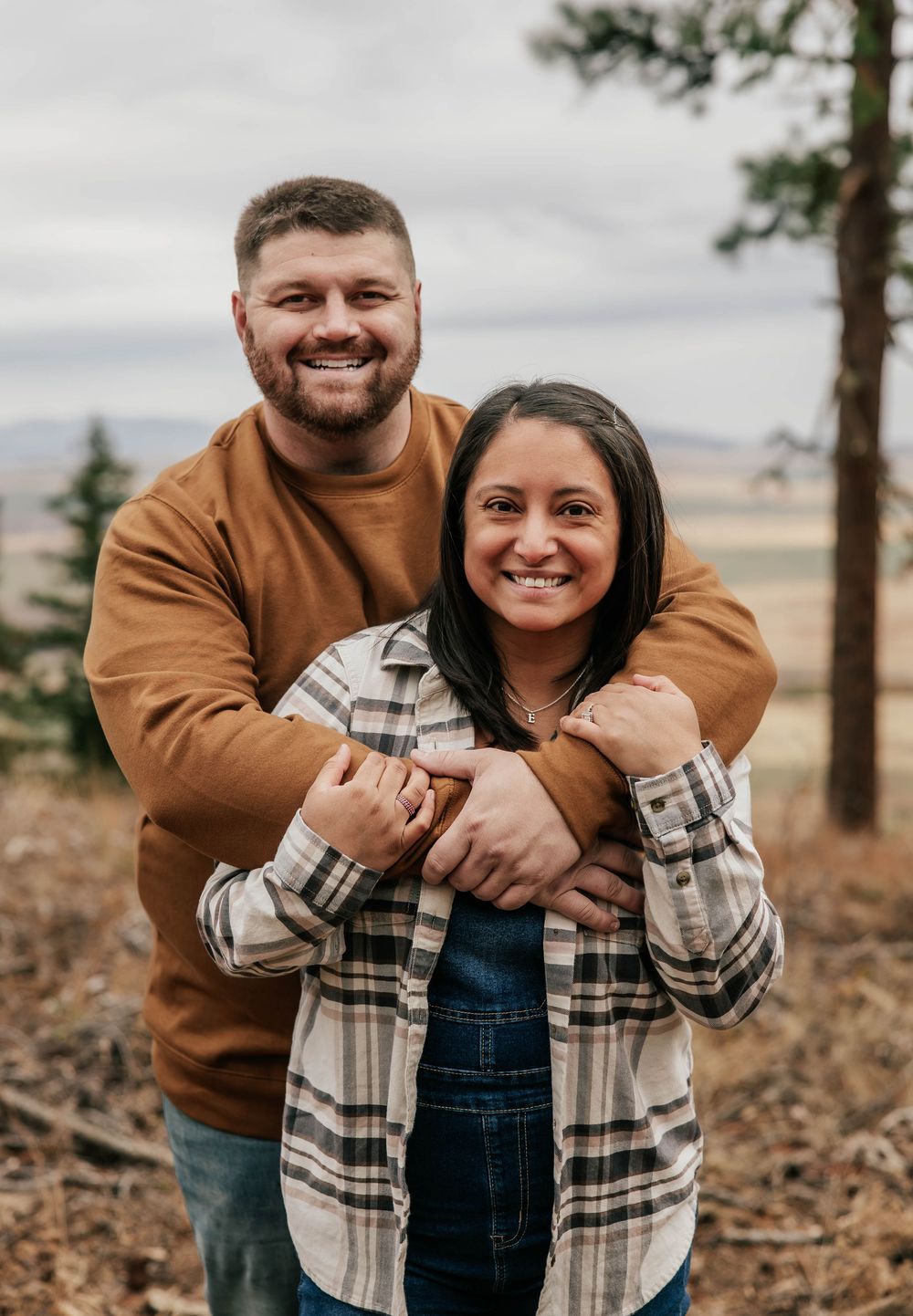 Sweet candid moments of a couple hugging and laughing together in nature.