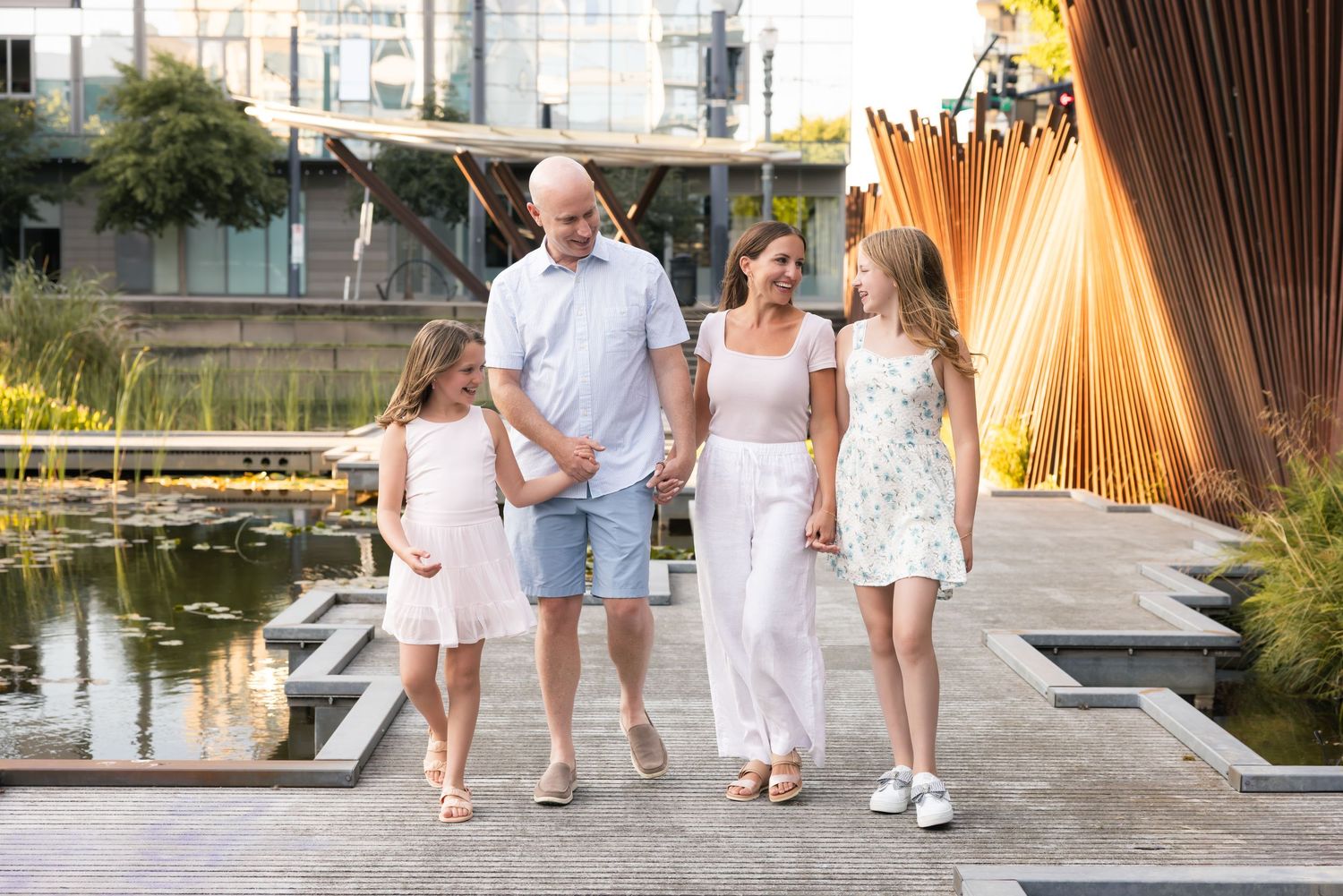 Family wearing casual clothes shares tender moments together during golden hour outdoor photo session.
