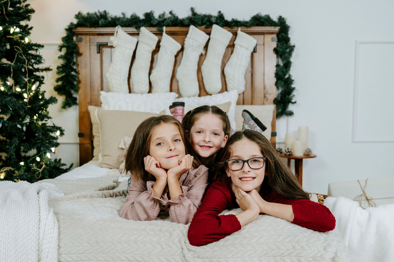 Family members smile and pose together in matching red and white outfits during a holiday photo session.