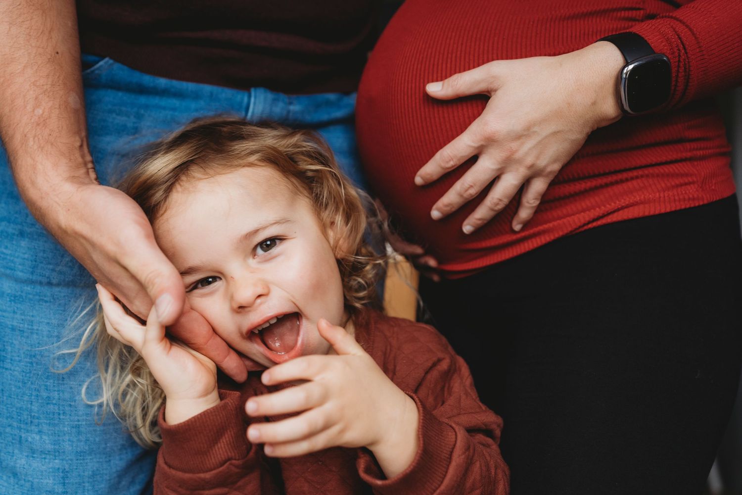 A sequence of four candid photos showing playful moments between parent and child on a blue couch.