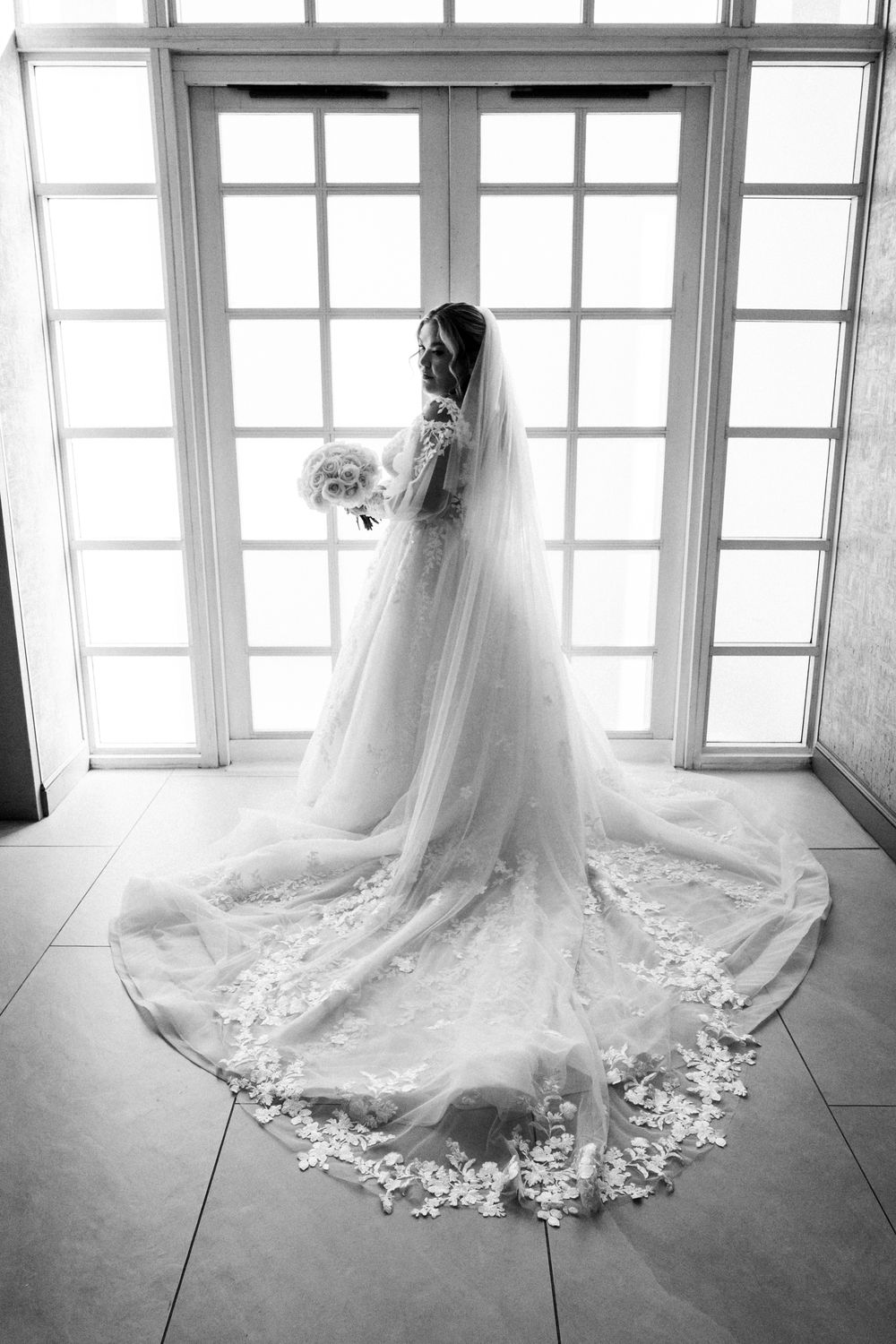 A series of black and white photos showing a flowing wedding dress train with delicate lace details against window light.