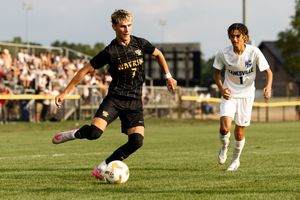 Soccer players compete for possession of the ball during an intense match on a grass field.