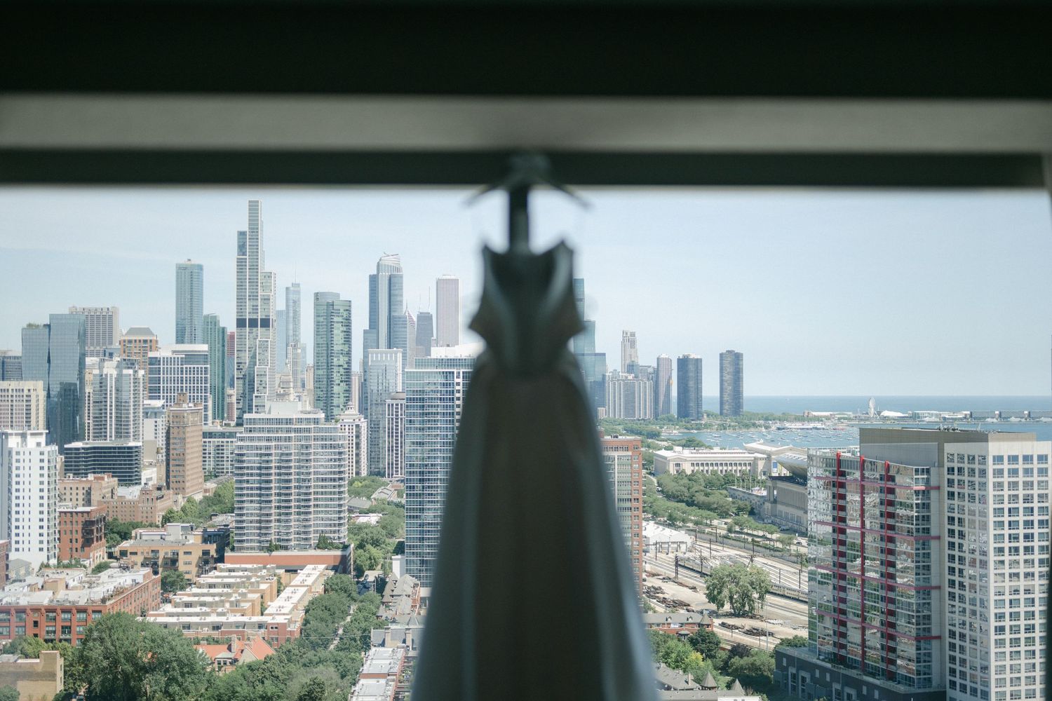 Panoramic cityscape view of Chicago's downtown skyline and Lake Michigan seen through a window on a sunny day.