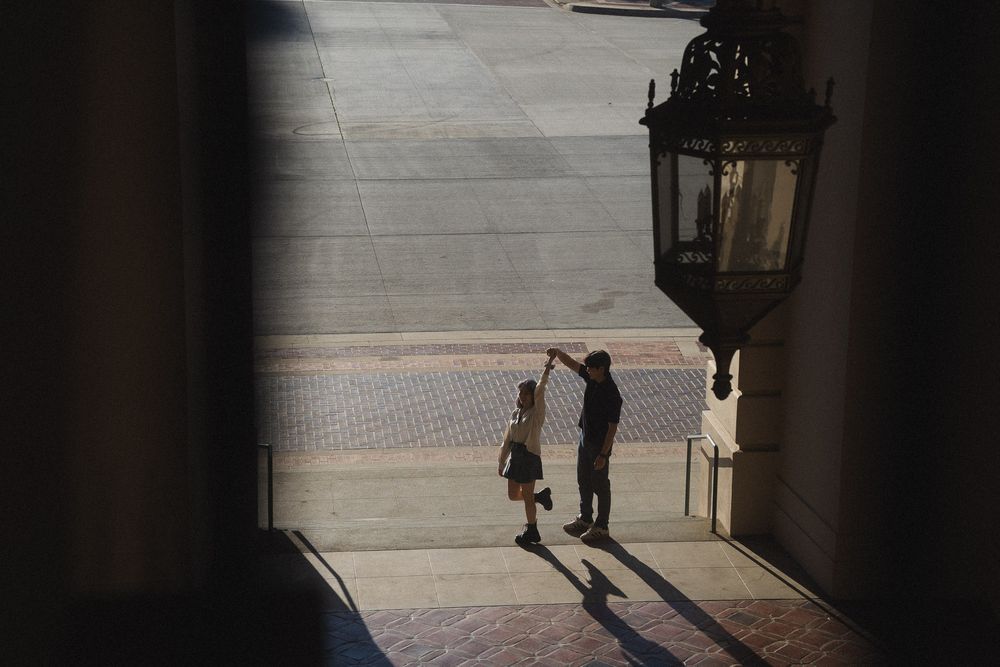 Romantic wide shot of couple dancing under the arches of Pasadena City Hall Los Angeles.