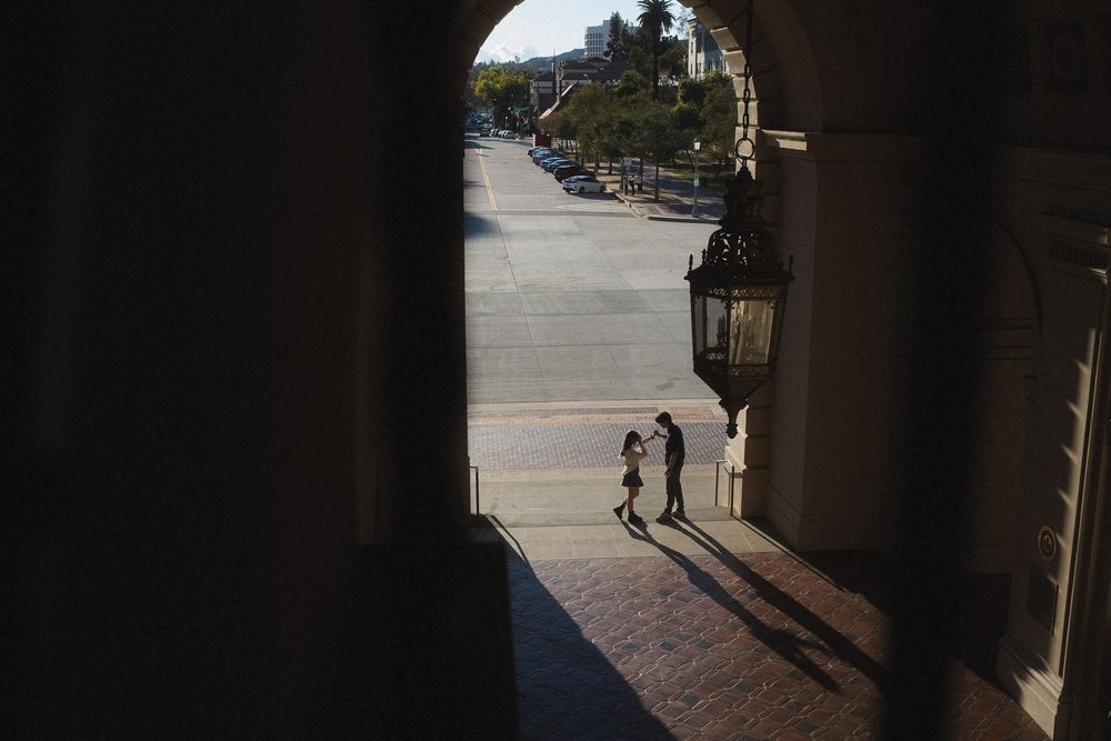 Cinematic portrait of couple exploring Pasadena City Hall architecture together.