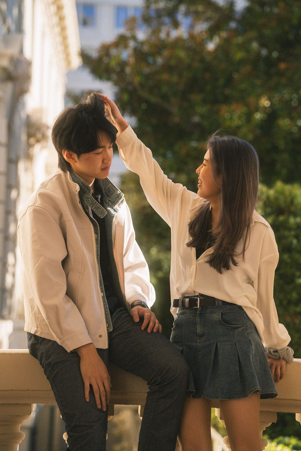 Playful moment of couple twirling under the warm evening sun at Pasadena City Hall.