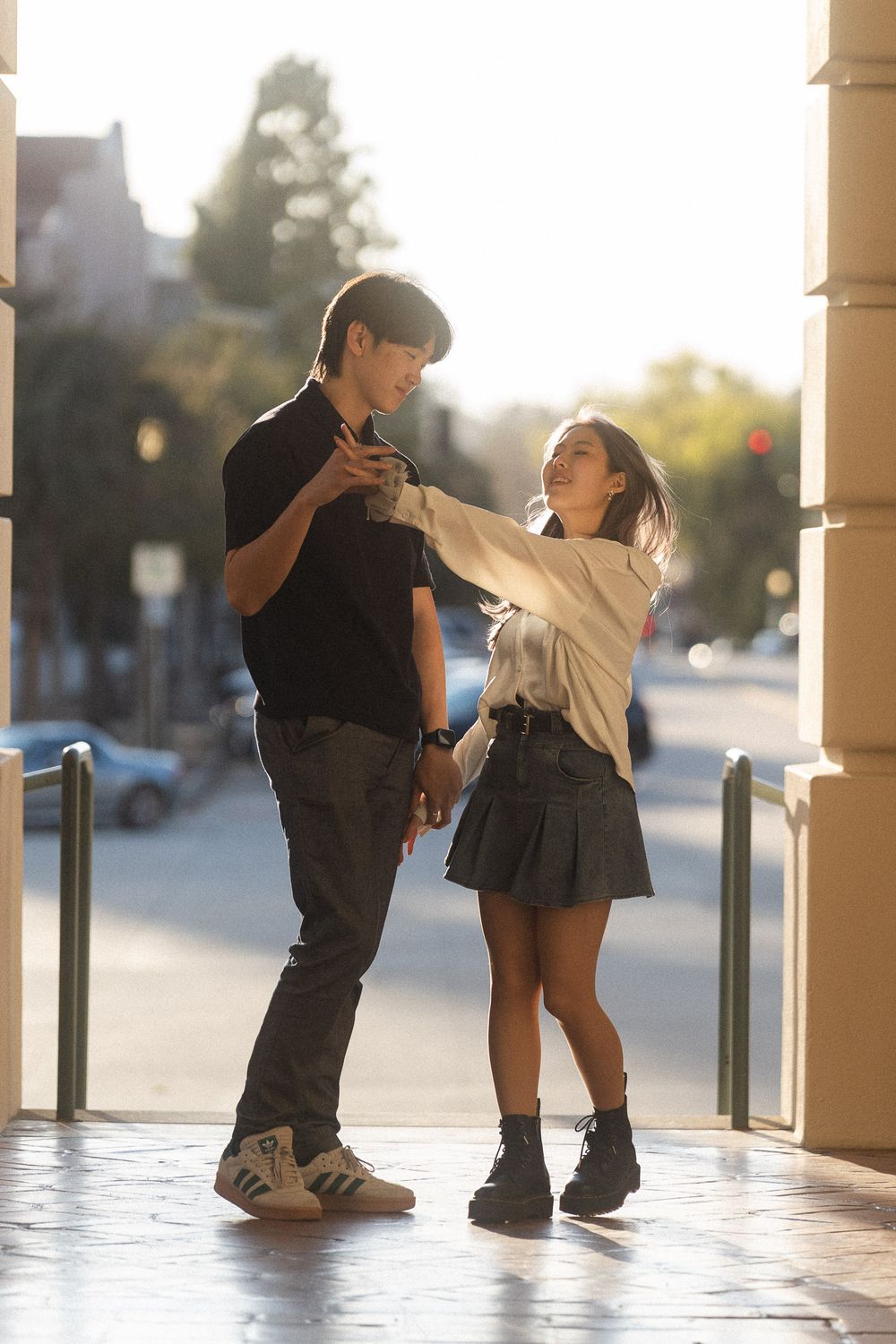 Couple framed by the elegant columns of Pasadena City Hall during sunset.