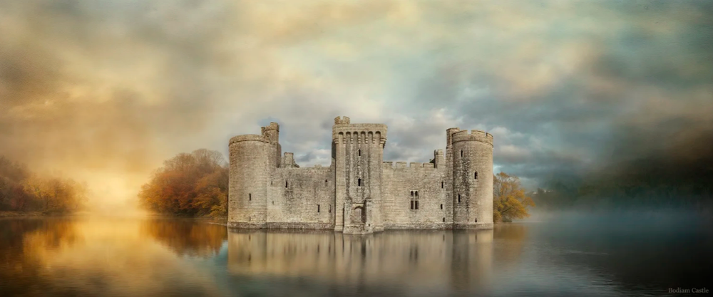 Ancient castle silhouetted against a moody sky with dramatic clouds at sunset.