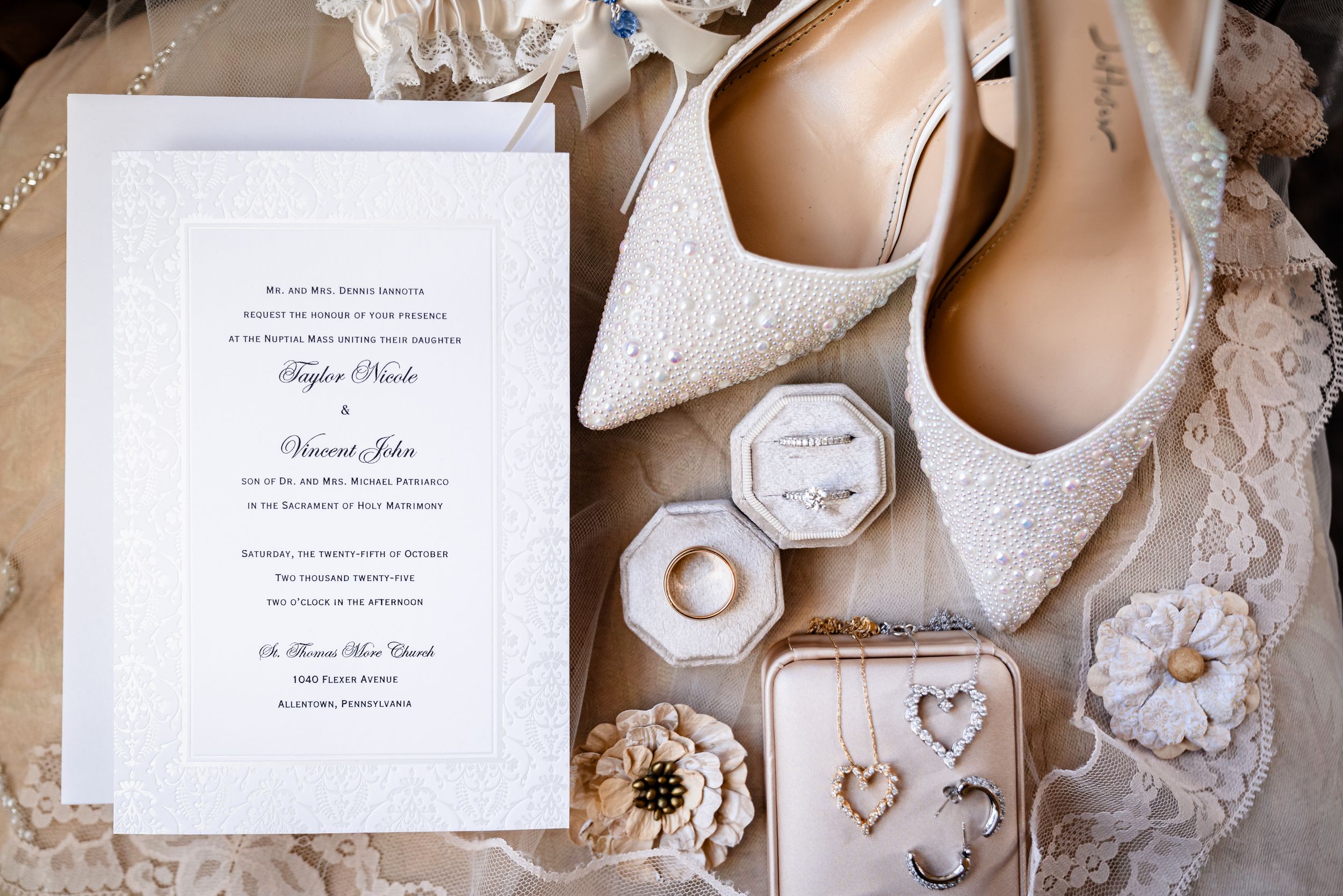 Wedding accessories flatlay with invitation, shoes, and delicate lace details.