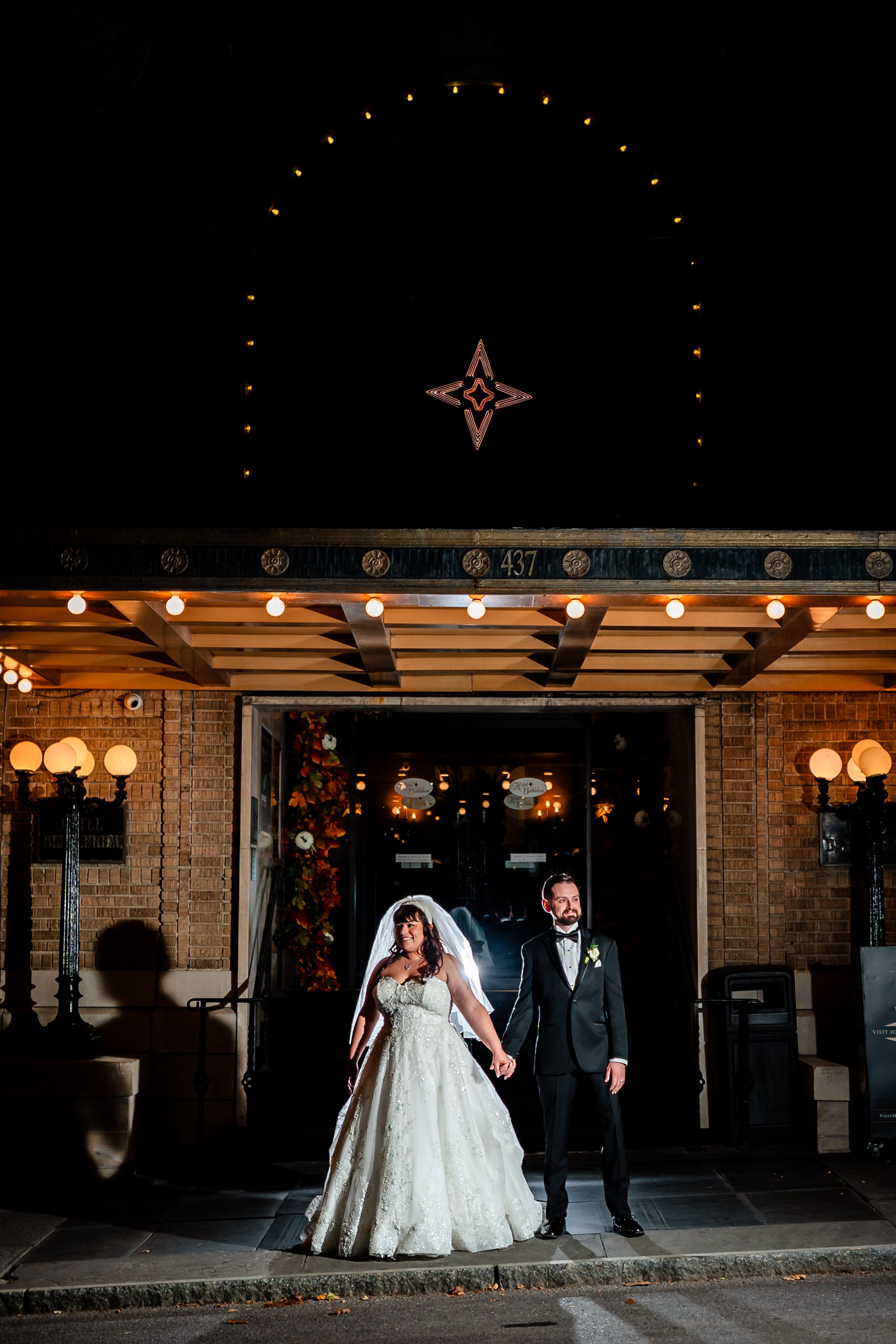 Wedding venue exterior with decorative string lights and illuminated star at night.