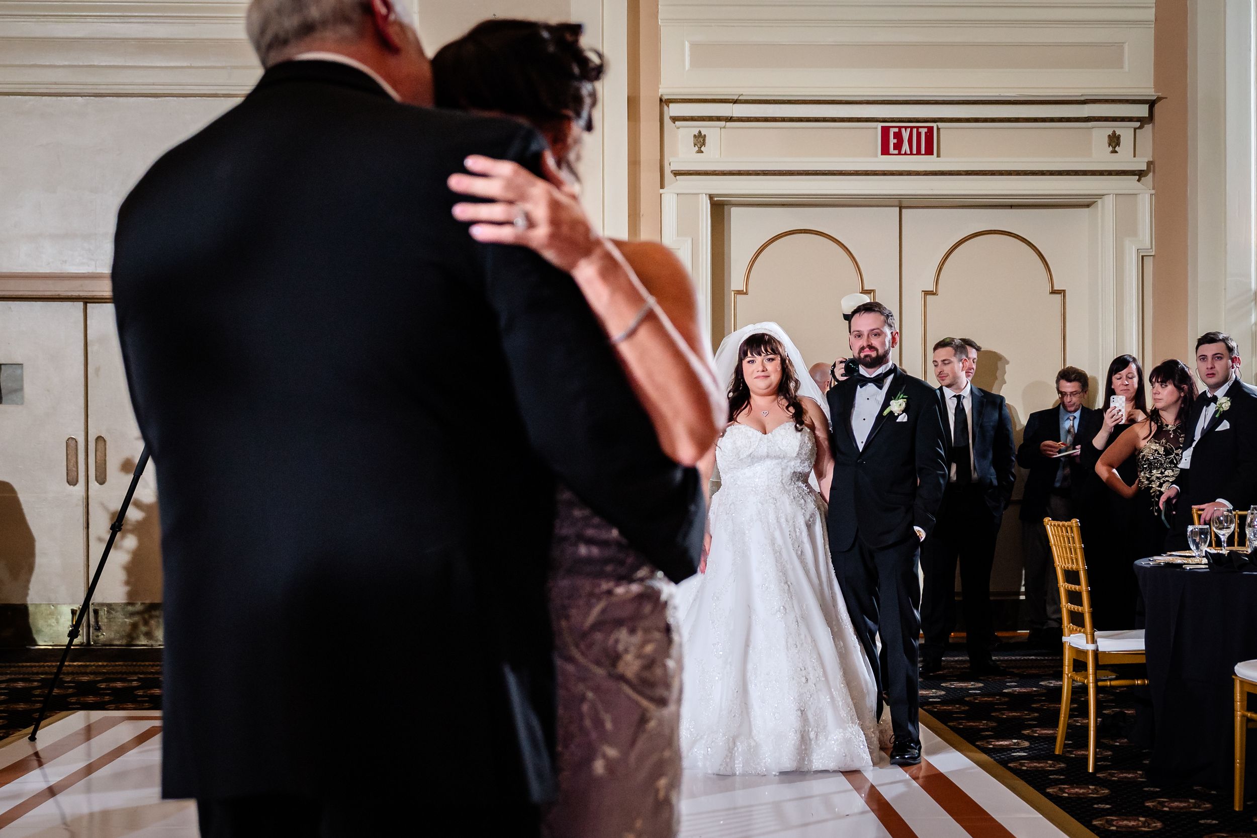 Wedding reception dance floor with guests gathered around in formal attire.