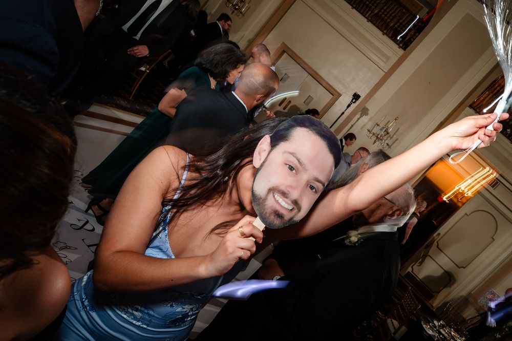 An energetic party guest dances and celebrates on the dance floor at a wedding reception.