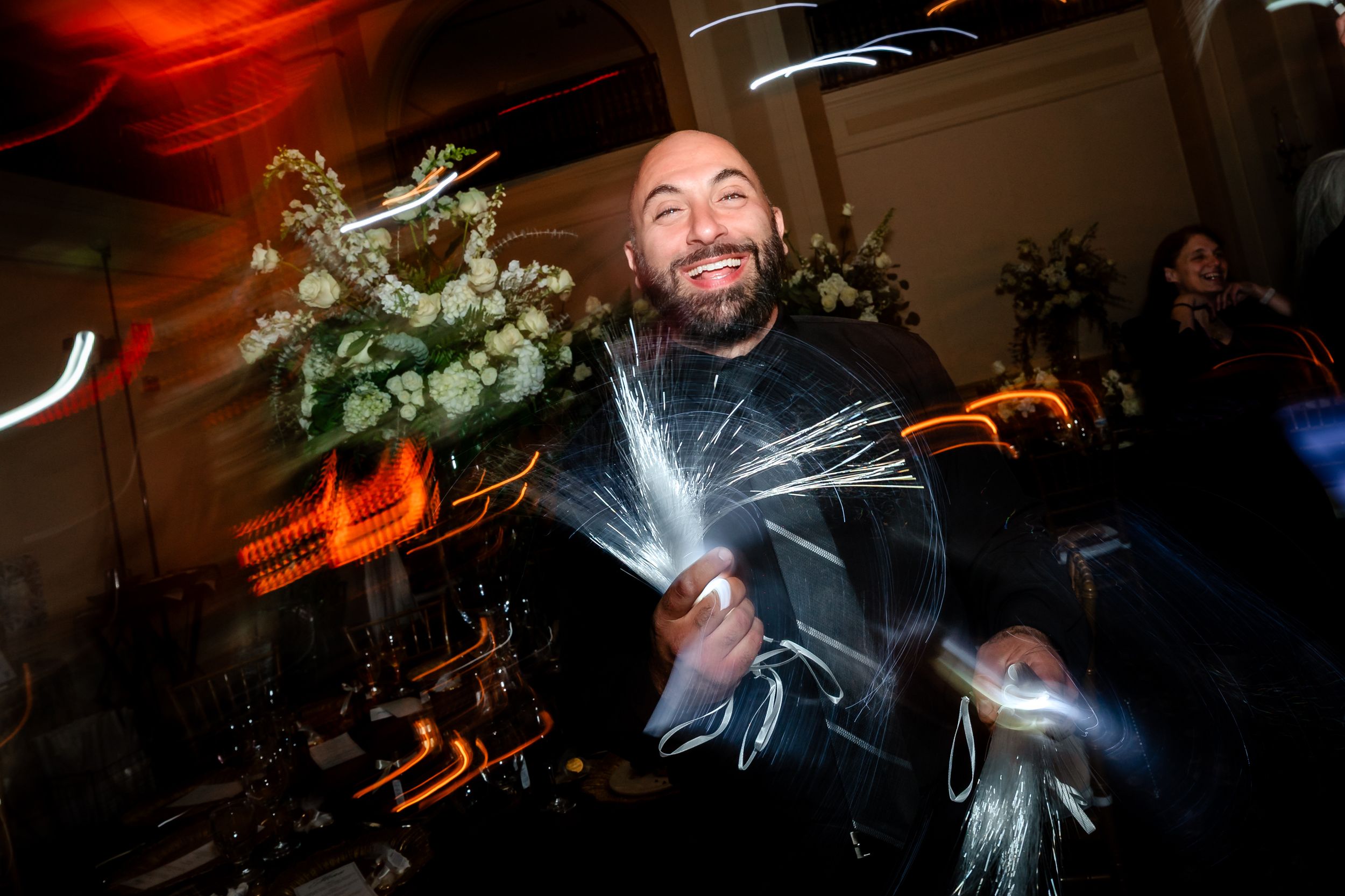 Dynamic nighttime wedding reception with colorful lighting and dancing.
