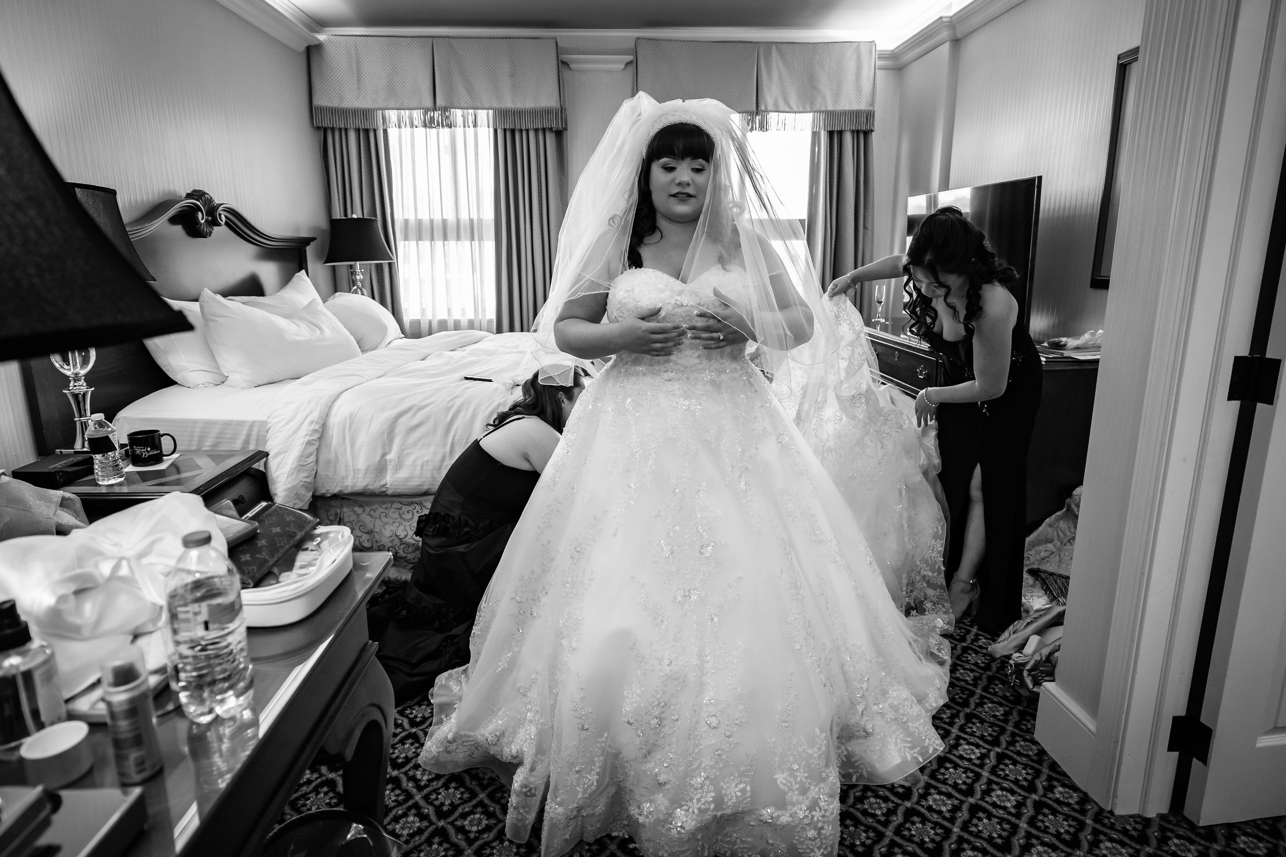 Wide panoramic shot shows bridal preparations in a hotel room.