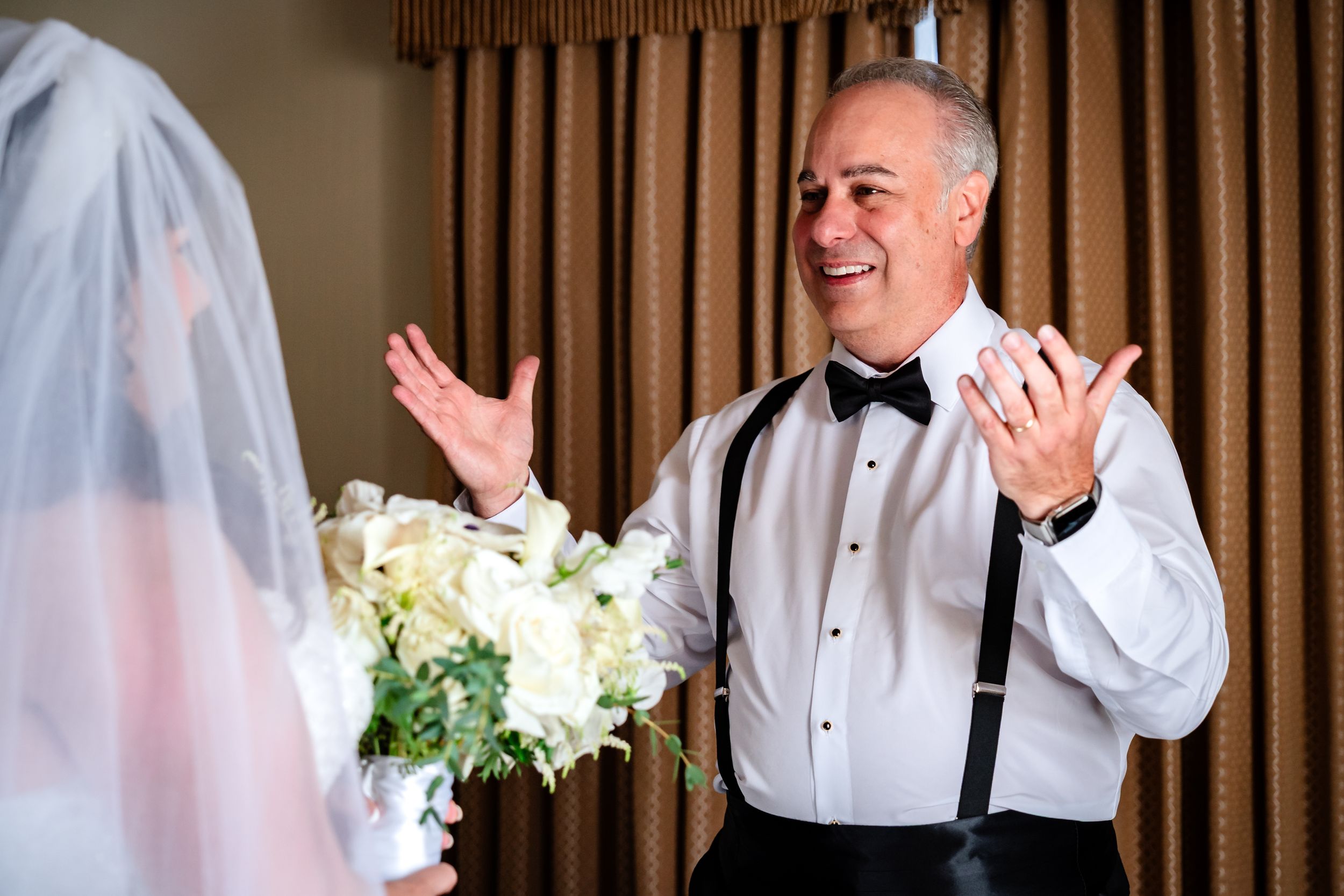 A joyful moment during wedding preparations in a hotel room.