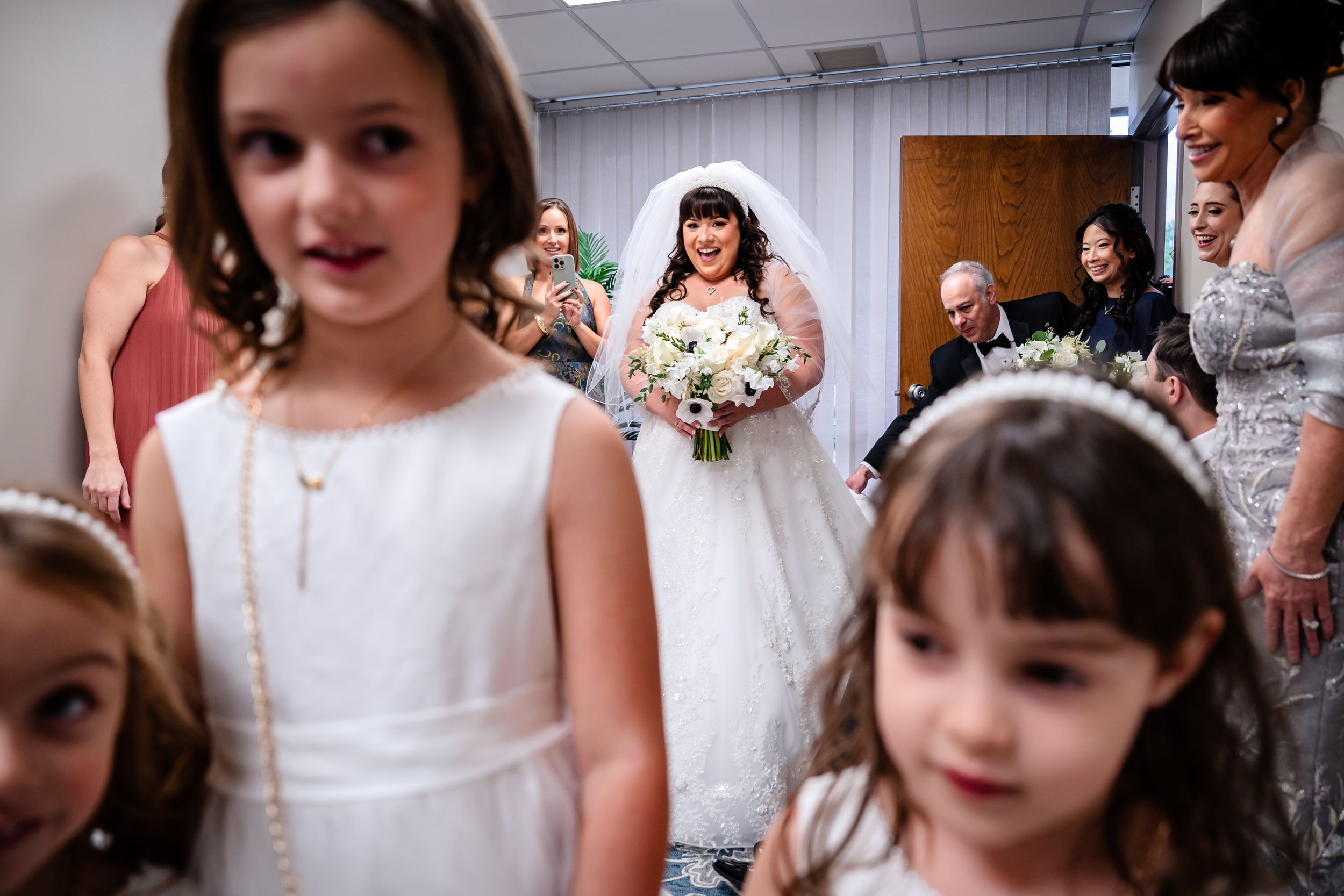 Wedding party preparations with white dresses and floral details.