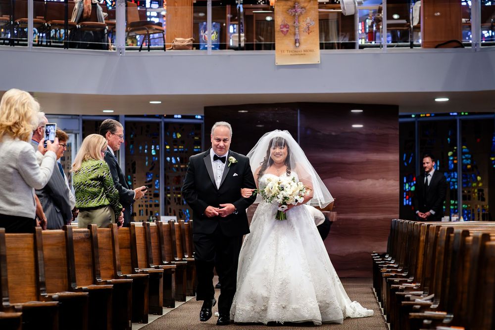 Traditional church wedding ceremony with wooden pews and processional aisle.