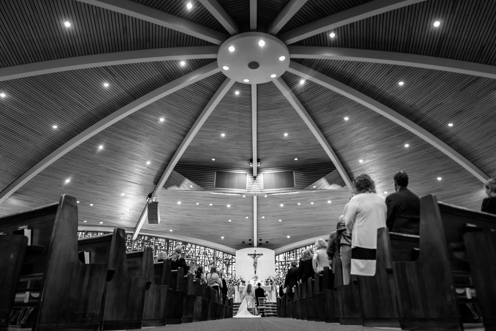 Wedding ceremony under dramatic domed ceiling with modern lighting.