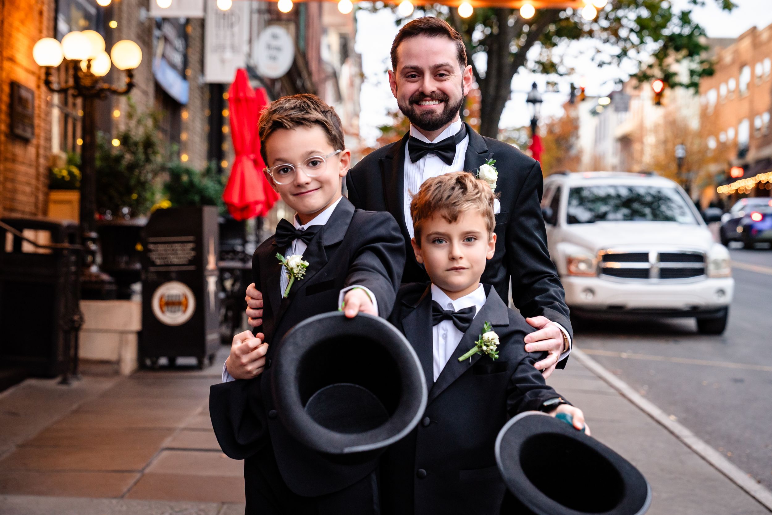 Wedding party poses in formal attire on city street.