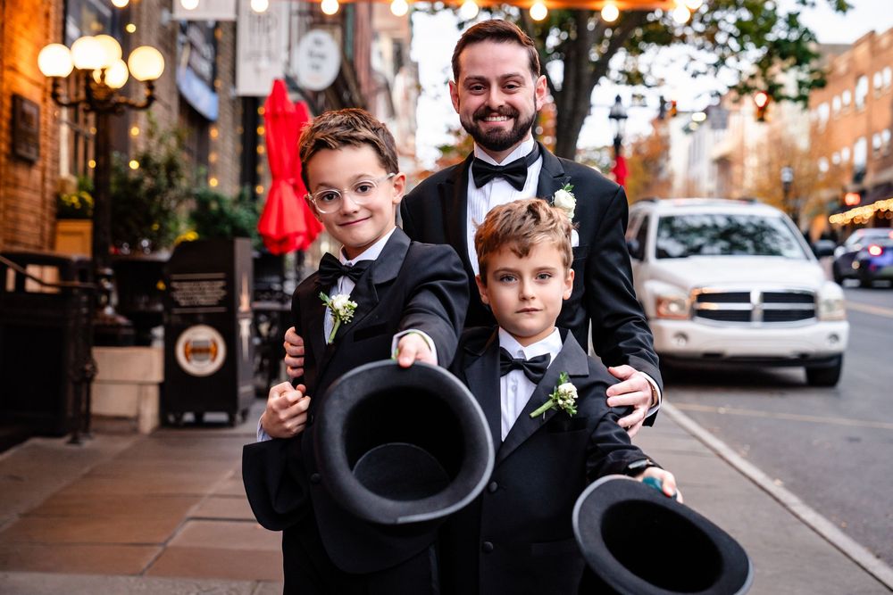 Wedding party poses in formal attire on city street.