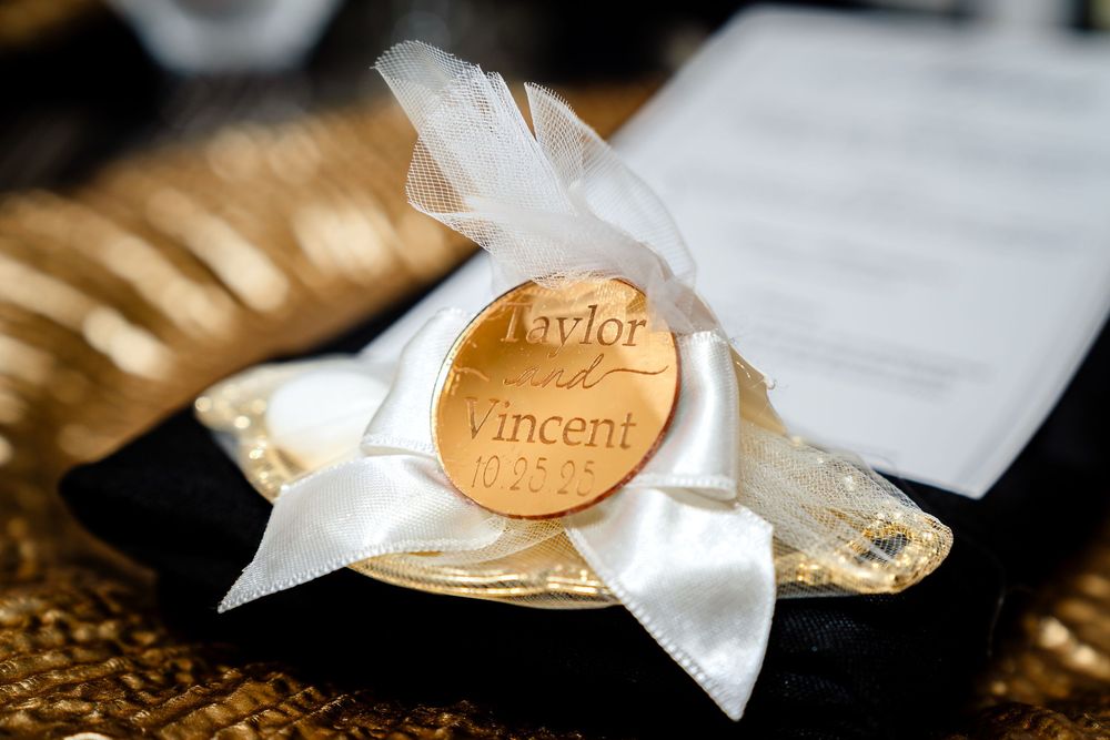 Close-up details of wrapped wedding favors with golden ribbons on dark background.