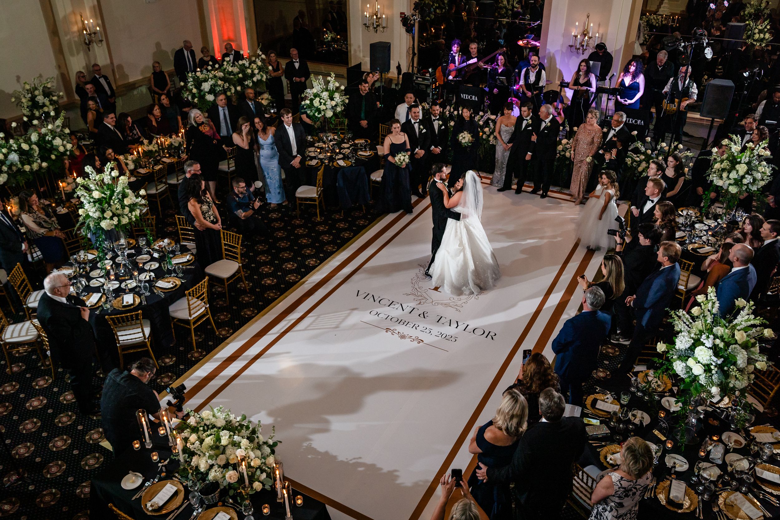 Aerial shot of a wedding ceremony space with white floral arrangements and dramatic lighting.