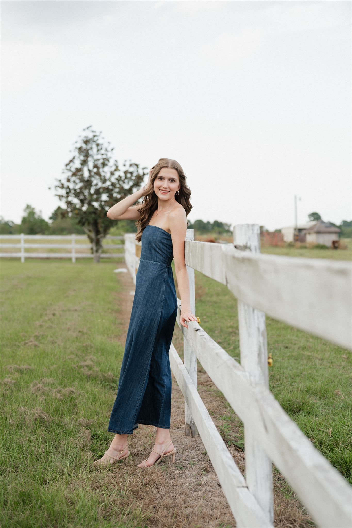 The Woodlands High School senior girl in a denim dress posing for pictures in Magnolia, Texas
