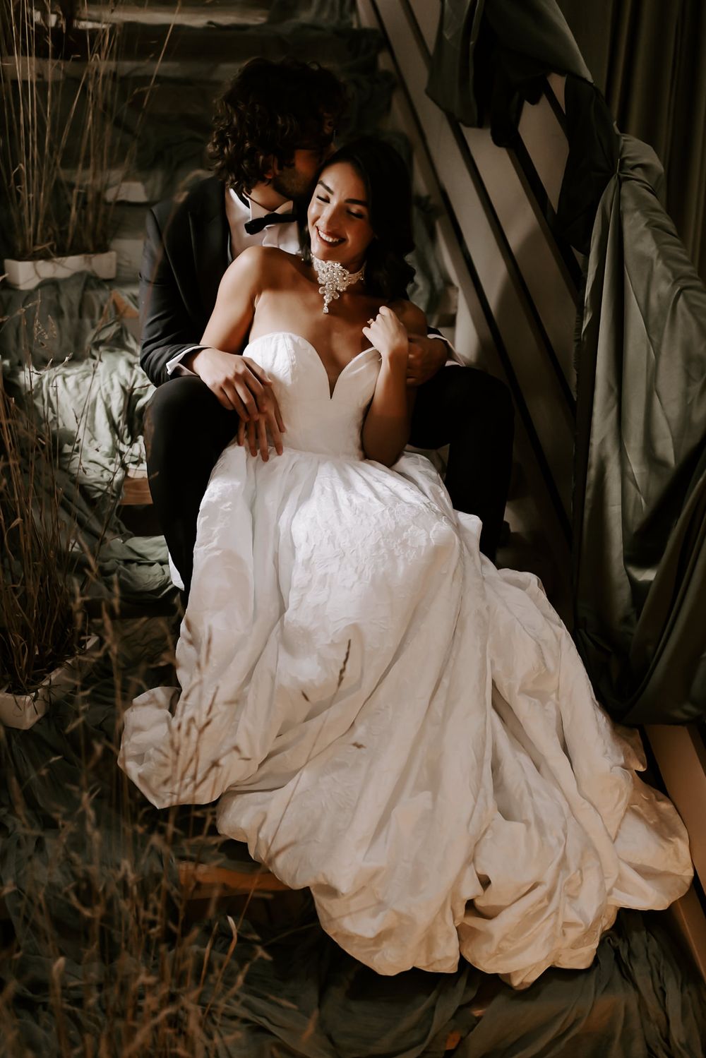 A romantic bridal portrait series showing flowing white wedding dress details in moody, dramatic lighting.