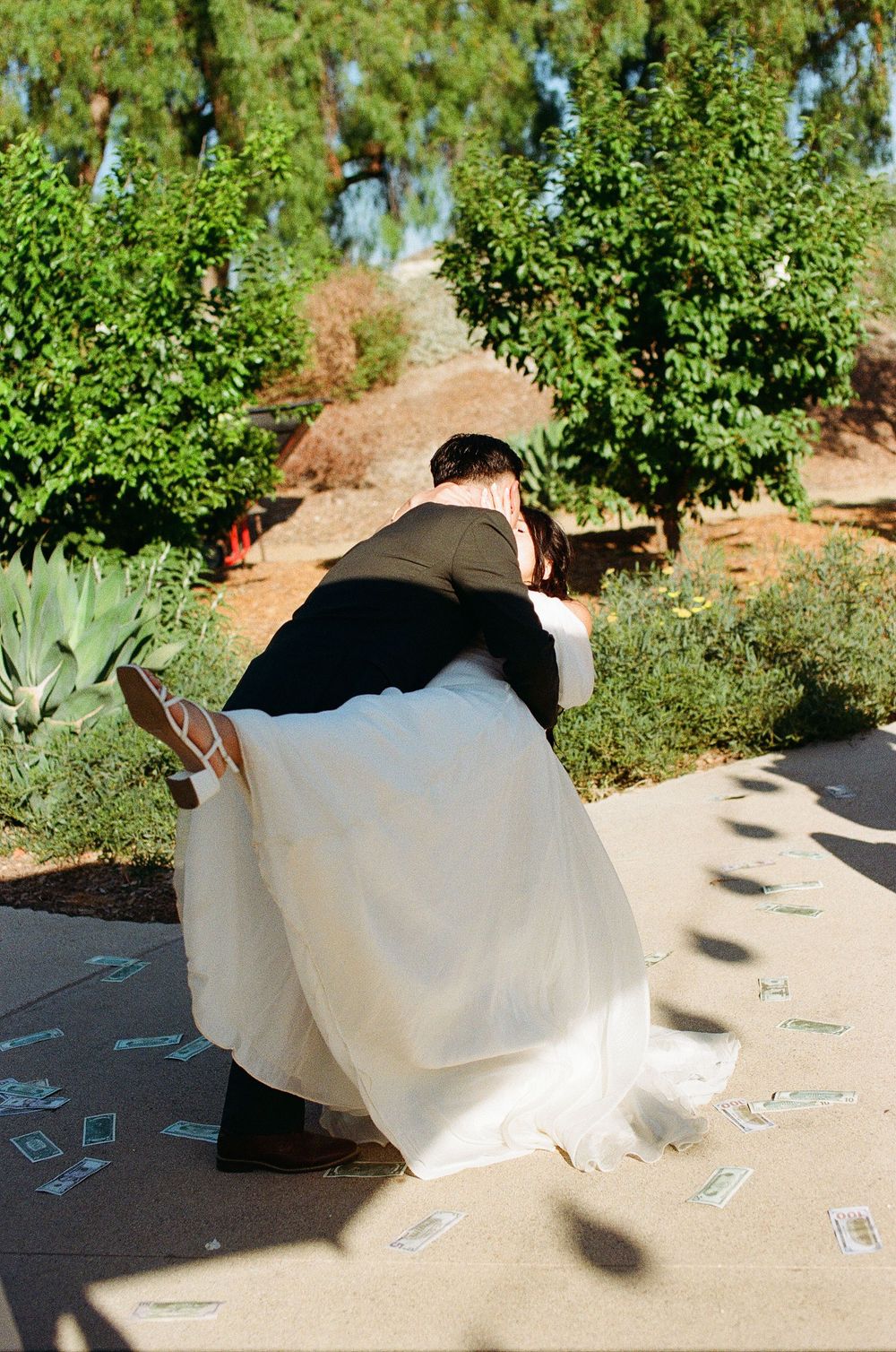 Cinematic Orange County film photography of the groom dipping the bride during their romantic outdoor ceremony.