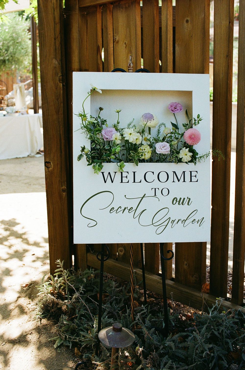 Detail shot of the "Welcome to Our Secret Garden" sign at the entrance to the Aliso Viejo wedding venue in Orange County.