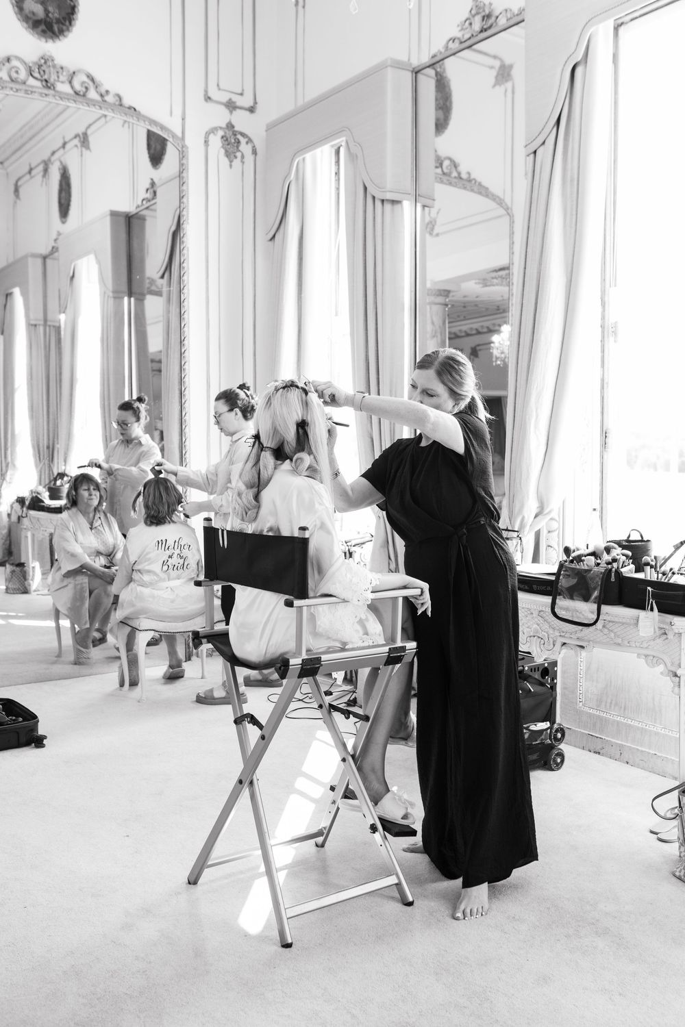 Black and white behind-the-scenes photos of a fashion shoot in an ornate room with vintage decor.