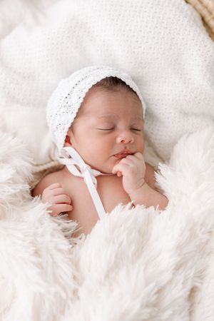 Photographie de nouveau-né dans une couverture douce et un bonnet de tricot léger au studio de photographie près de Québec de Judith Trudel