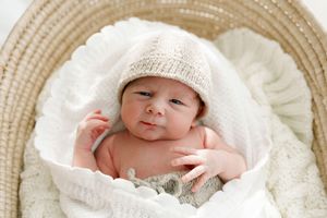 Photographie de nouveau-né dans une couverture douce et un bonnet de tricot léger au studio de photographie près de Québec de Judith Trudel