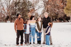 A sequence of winter outdoor family photos showing people walking together in the snow.