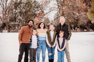 A group of people walking together outdoors in a snowy winter setting wearing casual clothing.