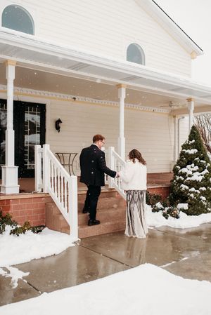 A sequence of four photos showing a couple in winter wedding attire walking up snowy porch steps.