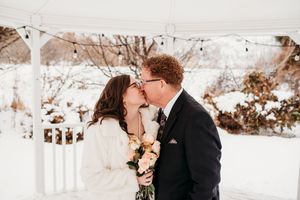 A romantic winter wedding photoshoot with couples embracing in a snowy outdoor setting.