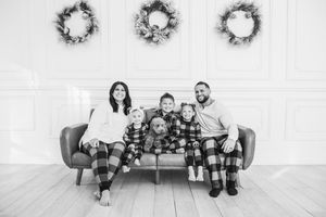 Black and white photo series showing people sitting and lounging together on a white couch in various playful poses.