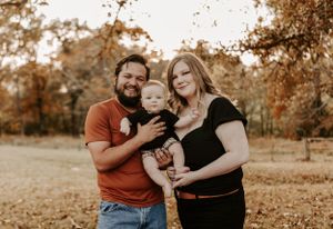 Natural family photography session in a golden field during fall season.