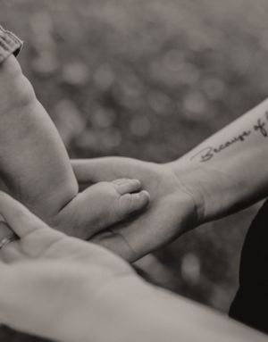 Close-up black and white image of hands tenderly touching.