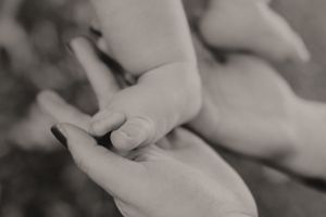Intimate black and white photograph of intertwined hands showing connection and emotion.