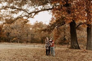 Wide landscape shot of a park setting with fall foliage and people in the distance.