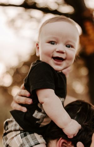 Close-up shots of a smiling baby in black clothing against a soft bokeh background.