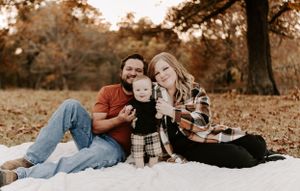 A romantic couple shares intimate moments while lying on blankets in a fall setting.