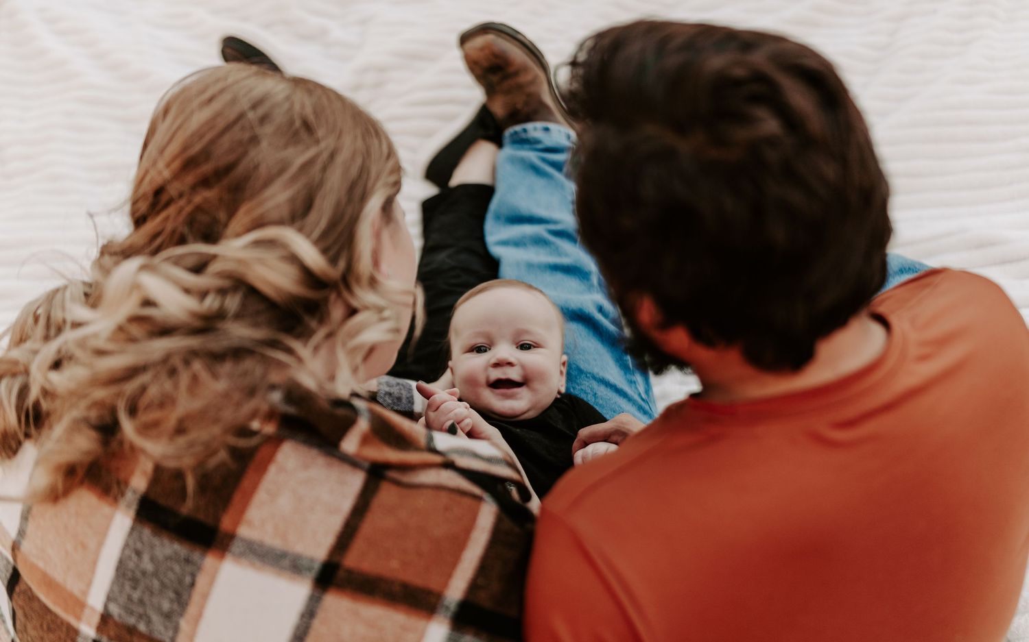 A cozy autumn photoshoot featuring a couple wrapped in blankets outdoors.