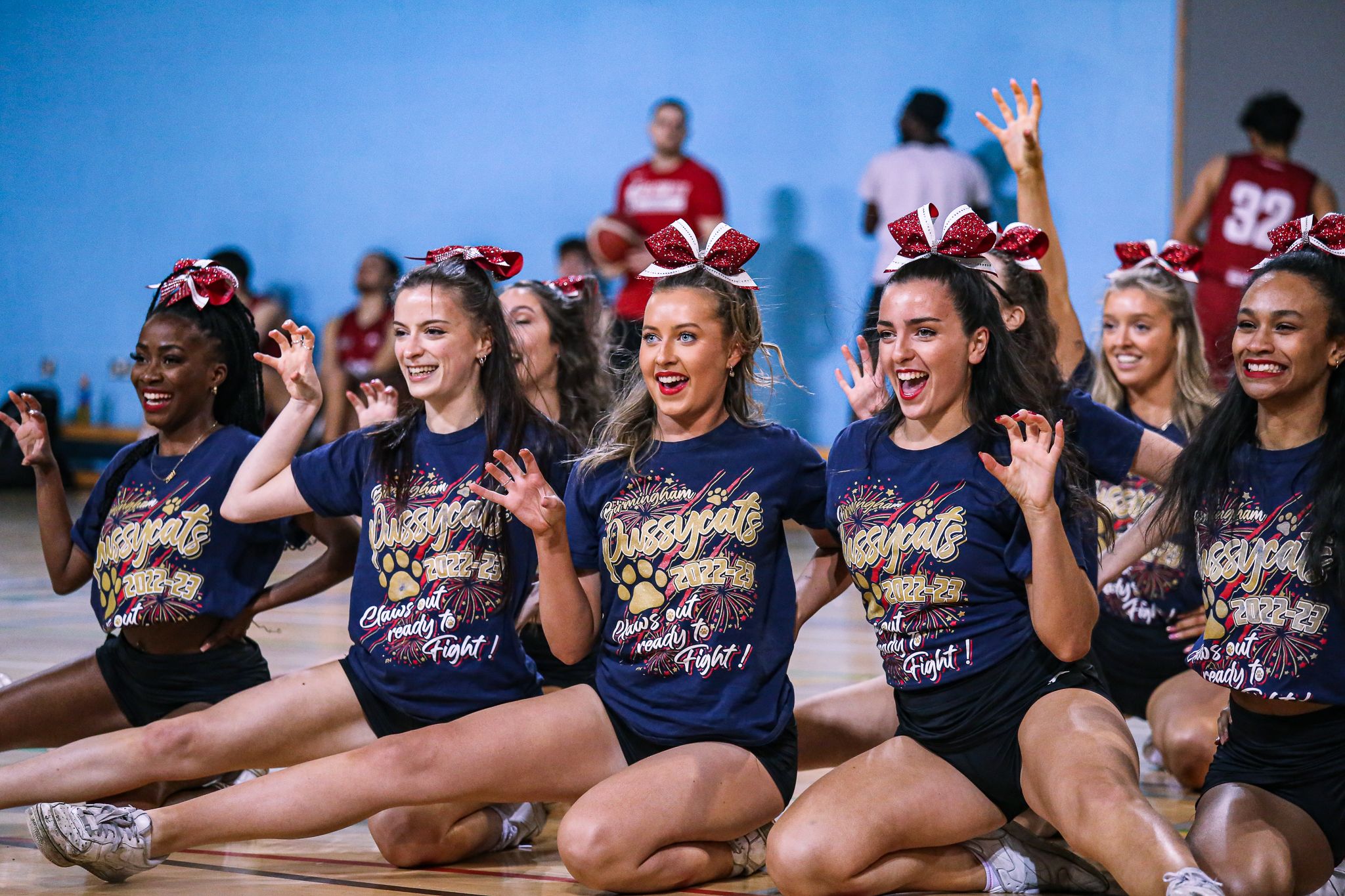 Cheerleaders smiling after their performance during the Rebellion basketball halftime show at the University of Birmingham