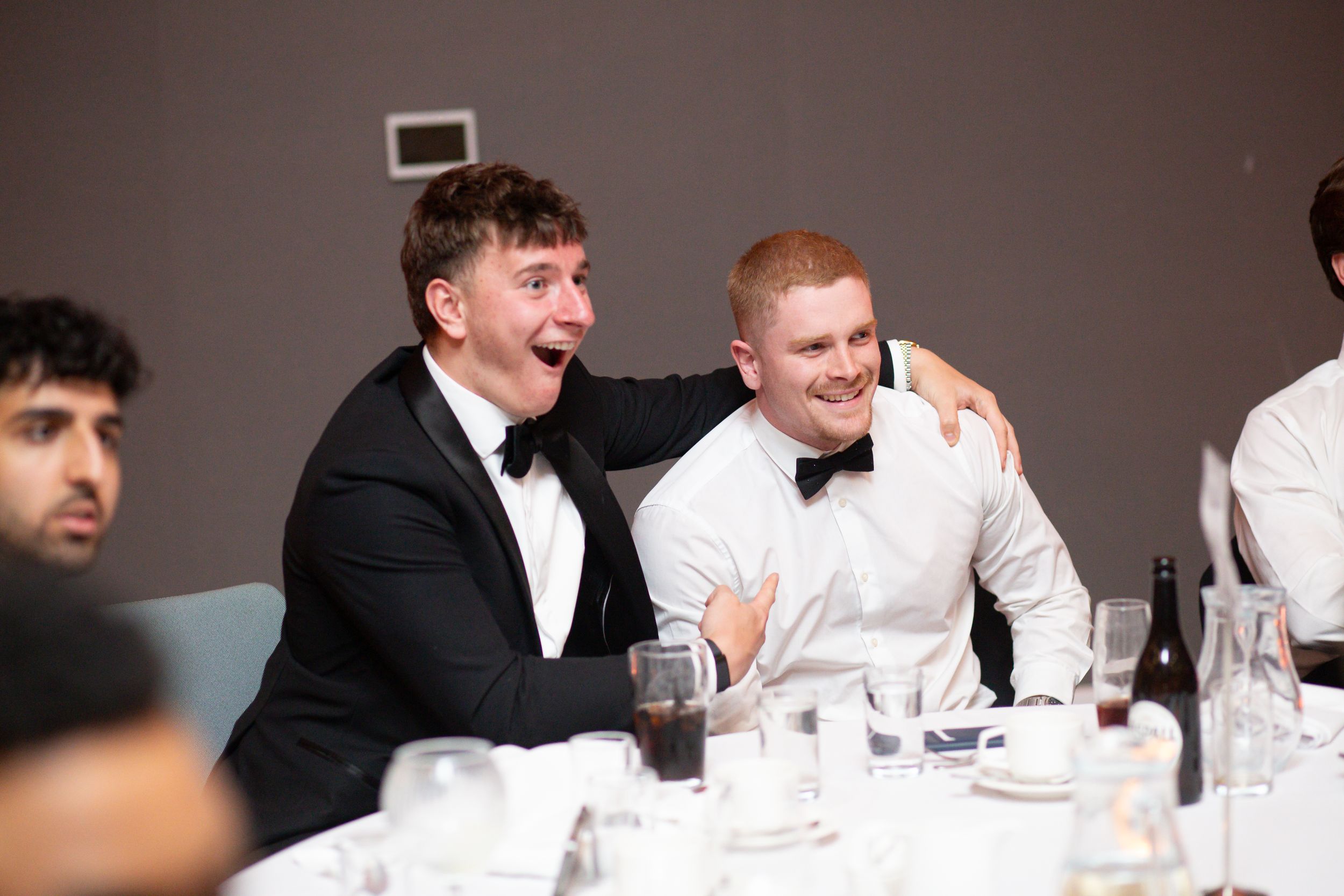 Two students smiling warmly at a formal student dinner at Edgbaston Park Hotel during university sports team event photography coverage.